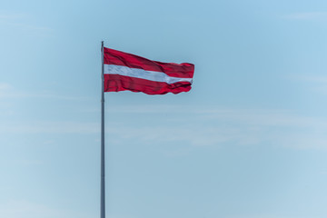 Latvian Flag on a Windy Day with a Sunny Sky