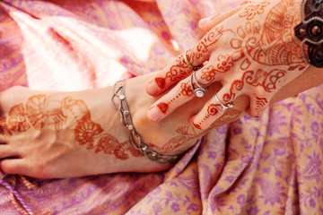 Female hand and leg decorated with traditional Indian henna