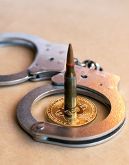 Obraz premium bullet, bitcoin and handcuffs as an abstract symbol of crimes and corruption