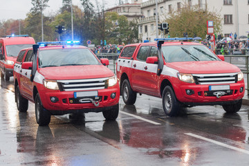Fire brigade workers riding cars on military parade
