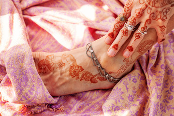 Female hand and leg decorated with traditional Indian henna