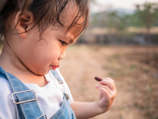 Asian little child testing the taste of fresh mulberry balls the beginning in the garden, First time to eating. Playing is learn to children.