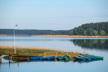 Landscape with the image of pier on lake Seliger in Svetlitsa village, Russia
