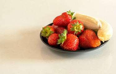 strawberries and bananas are on the table 