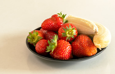 strawberries and bananas are on the table 