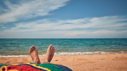 Fototapeta na wymiar Man lying and enjoying on a sandy tropical beach.