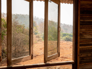Opened window of a wooden house in the garden.