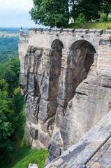 The fortress wall and the tower of an ancient medieval fortress on a cliff above the plains.