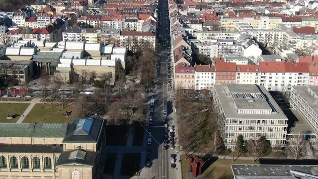 Long busy street with traffic and trams in Munich, aerial footage in 4k