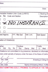 A close up of a traffic ticket with the words "No Insurance" written on it.