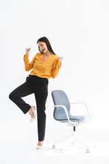 Full length portrait of excited young businesswoman dressed in elegant wear rejoicing and standing...