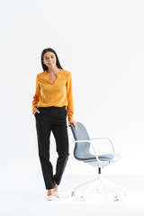 Full length portrait of charming young businesswoman dressed in elegant wear smiling and standing...