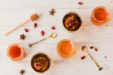 Fototapeta premium Composition with honey, tea and tea accessories on a white wooden background