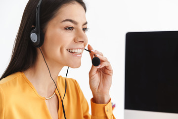 Photo of beautiful phone operator woman wearing microphone headset sitting in office and speaking...