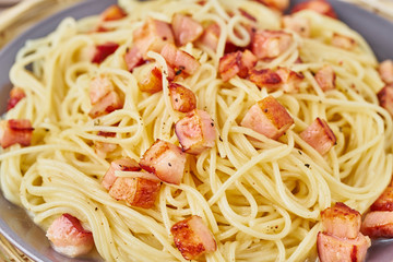 Close up carbonara pasta. Spaghetti with pancetta, egg, parmesan cheese and cream sauce. Side view. Traditional italian cuisine.