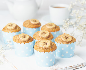 Banana muffin, cupcakes in blue cake cases paper, side view, close up, white concrete table