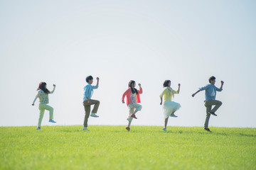 草原ではしゃぐ大学生