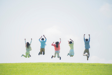 Fototapeta 草原でジャンプをする大学生の後姿 obraz