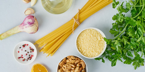 Step by step recipe. Pesto pasta, bavette with walnuts, parsley, garlic, nuts, olive oil. Top view, banner, ingredients, blue background.