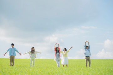 草原でリラックスをする大学生