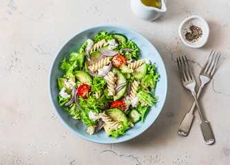 Mediterranean pasta avocado salad on a light background, top view. Vegetarian diet food concept