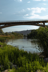 Fototapeta na wymiar Muddy river flowing under bridge. Redriver in Turkey