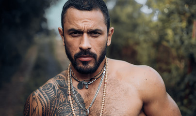 Handsome latino man, deep look. Sexy muscular young guy in the garden. Summer man and sensual...