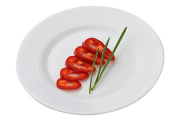 Red sweet bell pepper on a plate isolated on white background