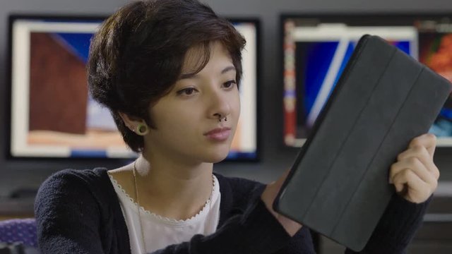 Young, hip female working on an ipad/tablet, extreme close up
