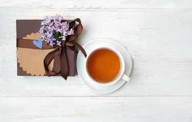 Fototapeta na wymiar flower, gift box and cup of tea on white background. concept birthday, gift for dad, men, brutal style. holiday greeting background. top view, copy space