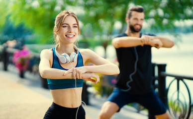 Photo of happy couple doing exercises together, outdoors
