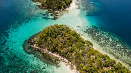 Paradise islands with white sand, palm trees and crystal blue water in Palawan, The Philippines