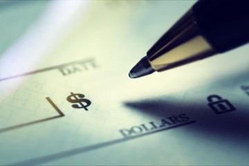 Pen writing a finance check concept