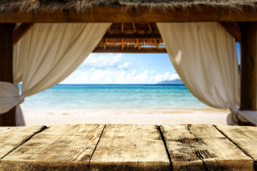 Wooden desk of free space and summer background of beach with sea and wooden window. Summer time 