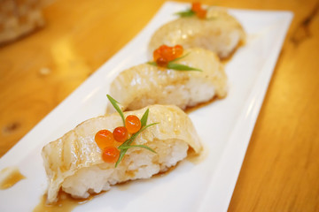Aburi engawa sushi - Grilled flatfish (Fluke fin) on rice topping with salmon roe (Ikura) served...