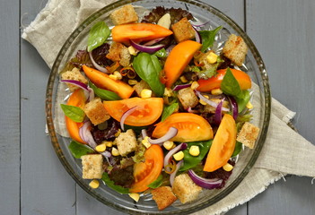 Salad with yellow tomatoes, sweet corn, basil and croutons, panzanella, view from above