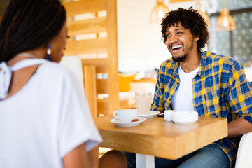 Laughing young couple in cafe, having a great time together