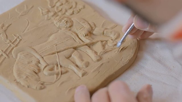 Professional male potter making clay stamp picture. Handwork, crafting and traditional arts concept