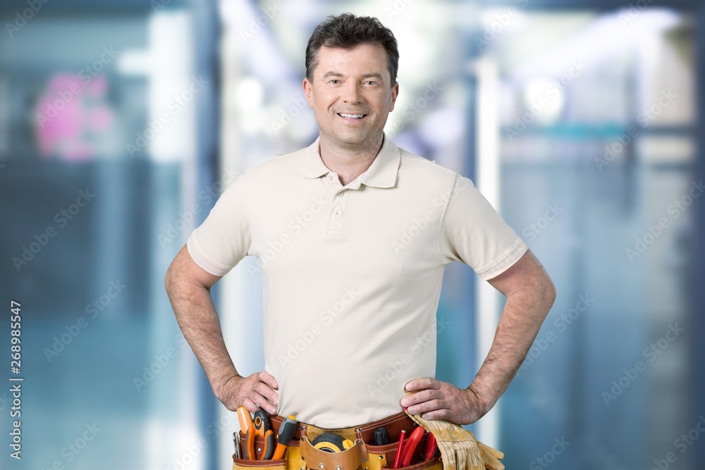 Wall mural smiling handsome plumber man. isolated white background.