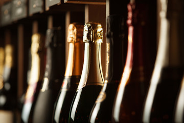 Underground cellar with elite sparkling wine on shelves, close up horizontal photo.