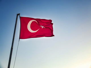 Turkish flag is waving against sky at the background