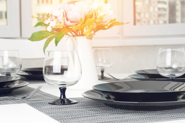 Kitchen white table served with plates, forks and glasses