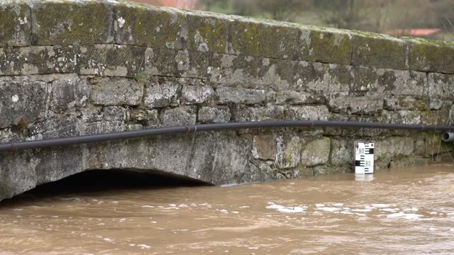 Hochwasser an einer Br&uuml;cke &uuml;ber einen kleinen Bach im Fr&uuml;hling