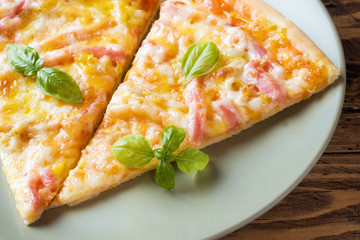 Pieces of homemade pizza on a plate on a wooden table.