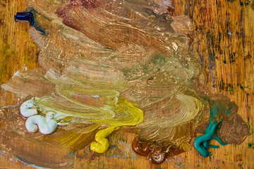 creative image, artist's palette with oil paints and brushes, close-up, old wooden palette, paints of different colors