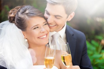 Young Wedding Couple Bride and Groom holding champagne glasses