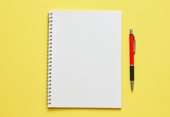 White notebook in an office setting on a yellow background
