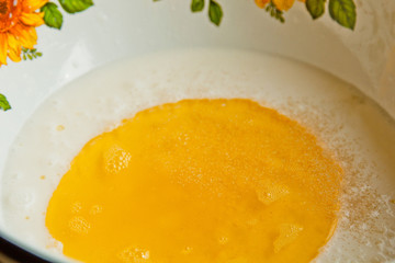 oil poured into milk in a metal bowl. dough preparation stage. recipe puff pastry. baking ingredients closeup top view