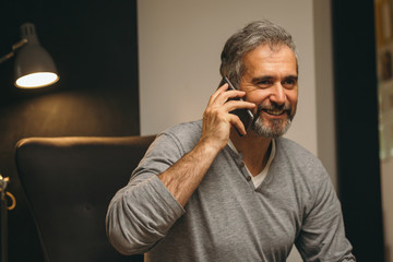 middle aged man using cellphone in his home