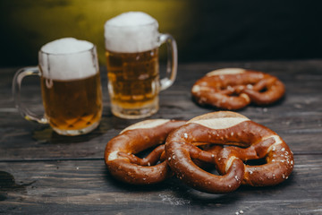 pretzels and beer in mug on dark wooden table